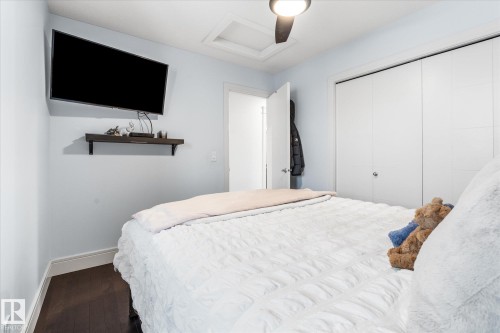 Bedroom featuring rich wood-finish flooring, a ceiling fan with integrated lighting, and a white bi-fold closet - 6 Sedona Place, Fort Saskatchewan, AB - Indoor Photo Showing Bedroom
