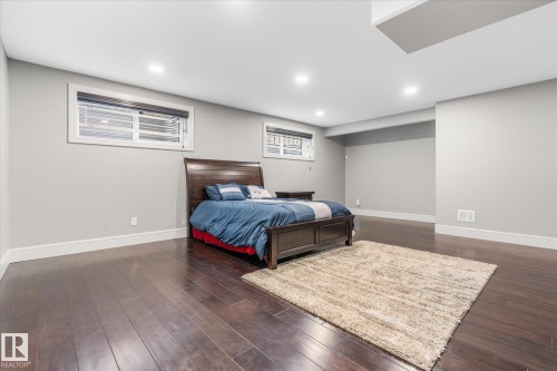 Spacious room featuring dark wood-finish flooring, recessed lighting, and light grey walls - 6 Sedona Place, Fort Saskatchewan, AB - Indoor