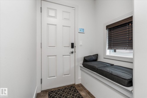Entryway featuring a paneled door with digital lock, built-in window bench, and wood-finish flooring - 6 Sedona Place, Fort Saskatchewan, AB - Indoor Photo Showing Other Room