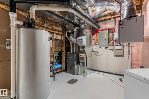 Utility room featuring a water heater, furnace system, extensive ductwork, exposed ceiling joists, and insulated walls - 6 Sedona Place, Fort Saskatchewan, AB - Indoor Photo Showing Basement