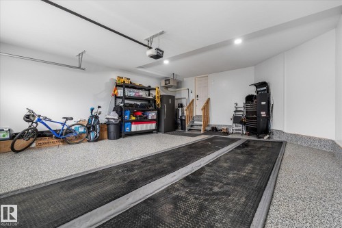 Spacious garage with light-colored speckled epoxy flooring and integrated rubber mats - 6 Sedona Place, Fort Saskatchewan, AB - Indoor Photo Showing Garage