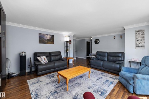 Spacious living area featuring wood-finish flooring, light gray wall paint, and white crown molding - 53257 Rge Road 211, Rural Strathcona County, AB - Indoor Photo Showing Living Room