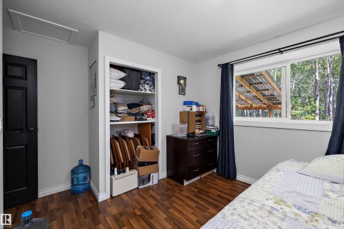 Room featuring wood-finish flooring, a white-framed window, and a built-in closet with shelving - 53257 Rge Road 211, Rural Strathcona County, AB - Indoor Photo Showing Bedroom