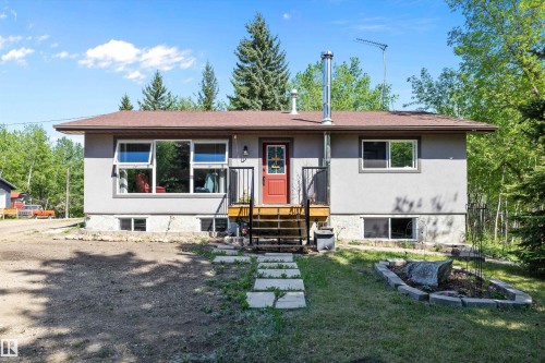 Stucco exterior featuring a red entry door and wooden steps - 53257 Rge Road 211, Rural Strathcona County, AB - Outdoor
