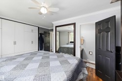 Bedroom featuring a white ceiling fan, wood-finish flooring, and crown molding - 