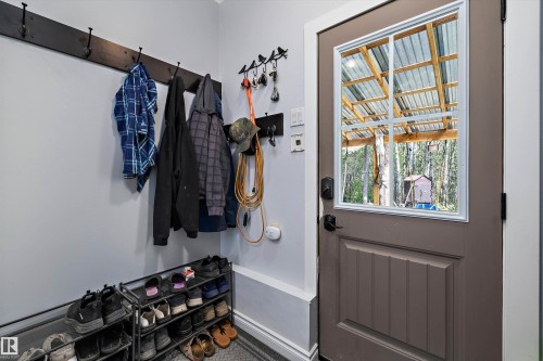 Entryway featuring a panel door with a window insert, wall-mounted coat hooks, and a neutral wall color - 53257 Rge Road 211, Rural Strathcona County, AB - Indoor