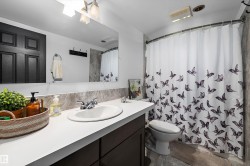 Bathroom featuring a white sink, chrome faucet, and a large mirror - 