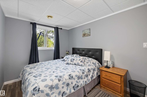 Interior room featuring wood-finish flooring, light gray wall paint, and a white grid ceiling - 53257 Rge Road 211, Rural Strathcona County, AB - Indoor Photo Showing Bedroom