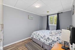 Room featuring grey painted walls, recessed lighting, white baseboards, wood-finish flooring, and a window with white trim - 