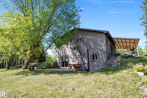 Stucco exterior residence with multiple windows and a covered outdoor patio - 53257 Rge Road 211, Rural Strathcona County, AB - Outdoor