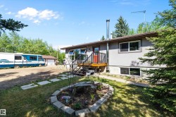 Split-level residence featuring a gray exterior and a brown trim roofline - 