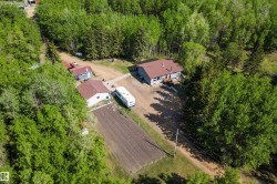 Aerial perspective showcasing a single-story home with a brown roof and a second auxiliary building - 