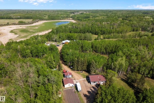 Expansive property featuring dense tree coverage, multiple structures, and a prominent pond - 53257 Rge Road 211, Rural Strathcona County, AB - Outdoor With View