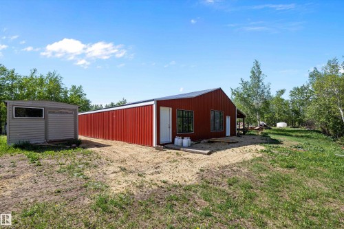 Red metal-sided structure with a dark roof and multiple windows - 53257 Rge Road 211, Rural Strathcona County, AB - Outdoor