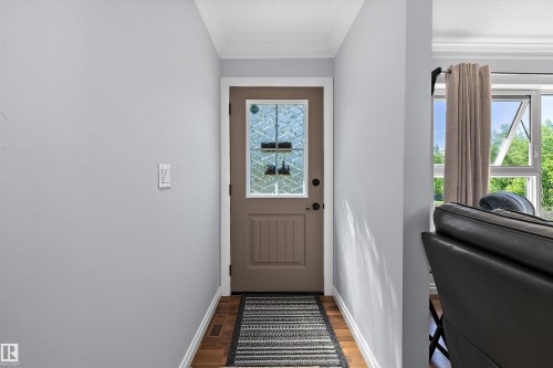 Entryway featuring a decorative glass panel door, wood-finish flooring, light grey walls, white baseboards, and crown molding - 53257 Rge Road 211, Rural Strathcona County, AB - Indoor Photo Showing Other Room