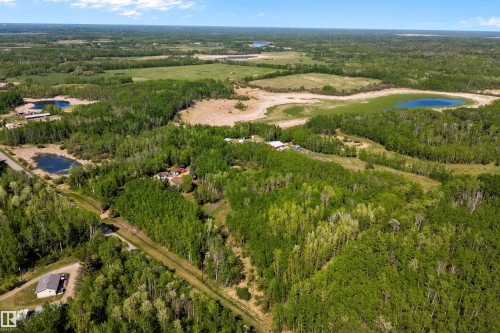 Expansive wooded property featuring multiple clearings, natural water bodies, and a visible road for access - 53257 Rge Road 211, Rural Strathcona County, AB - Outdoor With View