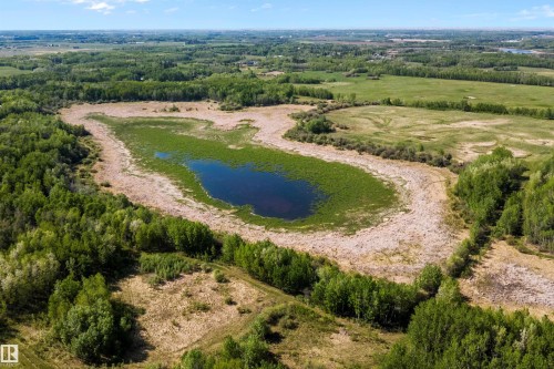 Natural landscape featuring a central body of water, extensive green foliage, surrounding fields, and scattered trees - 53257 Rge Road 211, Rural Strathcona County, AB - Outdoor With View