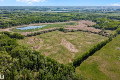 Expansive land parcel featuring open fields, a natural pond, and mature tree lines - 53257 Rge Road 211, Rural Strathcona County, AB - Outdoor With View