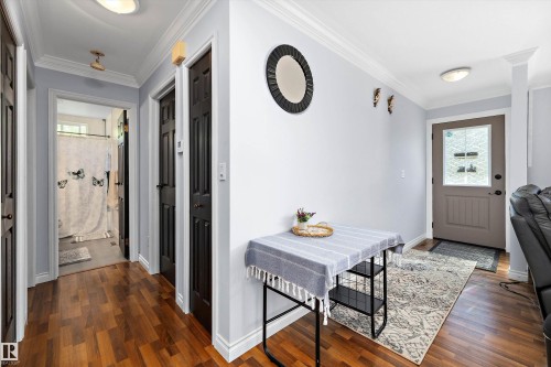 Entryway featuring wood-finish flooring, light gray walls, white crown molding, and a front door with a decorative glass insert - 53257 Rge Road 211, Rural Strathcona County, AB - Indoor Photo Showing Other Room