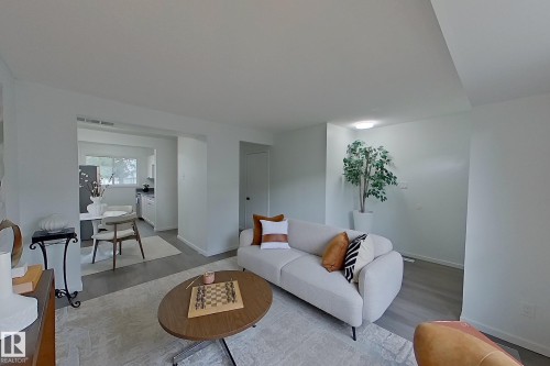 Open-concept living area with light gray wood-finish flooring and neutral wall tones - 209 Dickinsfield Court Nw, Edmonton, AB 