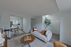 Open-concept living area with light gray wood-finish flooring and neutral wall tones - 