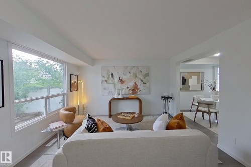 Light-filled living area featuring white walls and wood-finish flooring - 209 Dickinsfield Court Nw, Edmonton, AB 