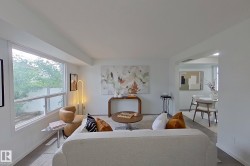 Light-filled living area featuring white walls and wood-finish flooring - 