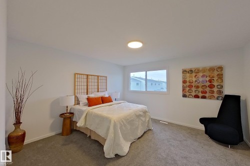 Spacious room featuring neutral carpeting, a large window, and a flush-mount ceiling light - 209 Dickinsfield Court Nw, Edmonton, AB 