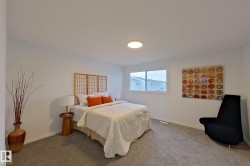 Spacious room featuring neutral carpeting, a large window, and a flush-mount ceiling light - 