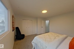 Carpeted room featuring a ceiling-mounted light fixture, a window with white trim, and a bi-fold closet - 