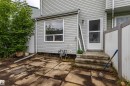 Rear exterior featuring light-colored siding and a concrete patio - 209 Dickinsfield Court Nw, Edmonton, AB  - Outdoor 
