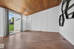 Vaulted wood-paneled ceiling accentuates an open living space with wood-finish flooring - 