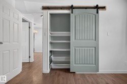 Custom barn door with black hardware, complementing a built-in shelving unit featuring pull-out wire baskets - 
