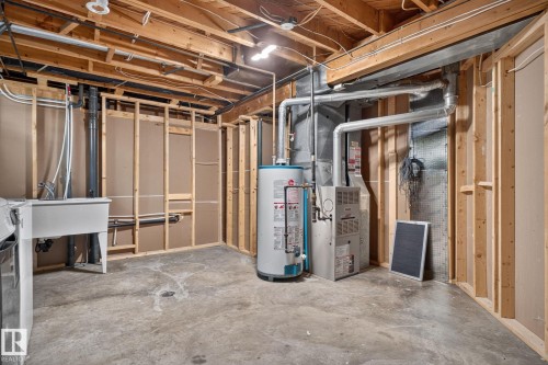 Unfinished basement with concrete flooring and exposed ceiling joists - 1071 Millbourne Road Nw, Edmonton, AB 