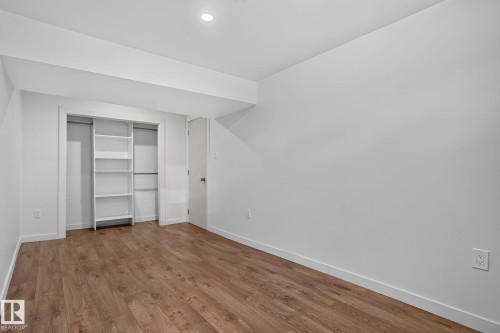 Interior room featuring wood-finish flooring, white painted walls, and recessed lighting - 1071 Millbourne Road Nw, Edmonton, AB 