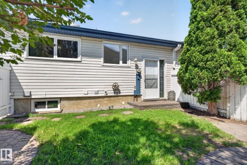 Rear exterior with horizontal siding, multiple windows, and a foundation - 1071 Millbourne Road Nw, Edmonton, AB 