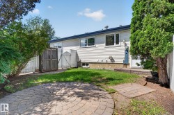 Rear exterior featuring light-colored siding, multiple windows, and a foundation - 