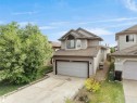 Two-story residence featuring light-toned siding, a two-car garage with a panel door, and a concrete driveway - 4021 158 Avenue Nw, Edmonton, AB  - Outdoor 