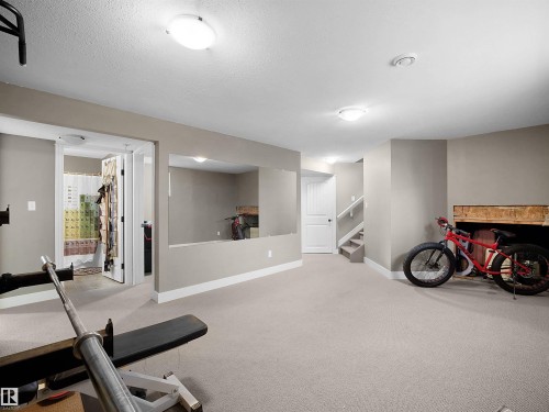 Carpeted lower level featuring neutral wall tones, recessed lighting, and a partial wall divider - 4021 158 Avenue Nw, Edmonton, AB - Indoor Photo Showing Gym Room