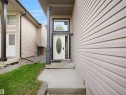 Front entry featuring a white oval-lite door with decorative glass, framed by dark trim and a transom window - 4021 158 Avenue Nw, Edmonton, AB  - Outdoor With Exterior 