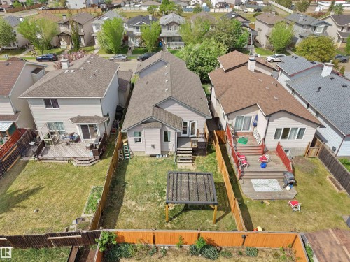 Fenced backyard with a wooden deck featuring stairs and red railings - 4021 158 Avenue Nw, Edmonton, AB - Outdoor