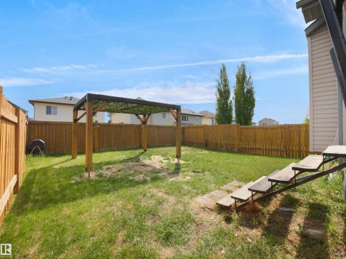 Expansive backyard featuring a wood pergola with shade covering, wood privacy fencing, and a grassy lawn - 4021 158 Avenue Nw, Edmonton, AB - Outdoor