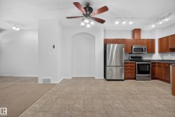 Kitchen featuring stainless steel appliances, wood cabinetry, and track lighting - 