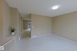 Carpeted interior space with neutral wall tones, white baseboards, and a flush-mount ceiling light fixture - 