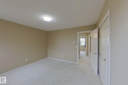 Carpeted room featuring a white bi-fold closet, neutral wall paint, and a circular ceiling light fixture - 