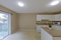 Kitchen area featuring white cabinetry, light countertops, and a central island - 