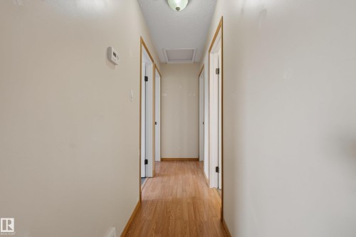 Hallway featuring wood-finish flooring, light neutral wall paint, and white trim - 3 Bristow Crescent, Spruce Grove, AB - Indoor Photo Showing Other Room