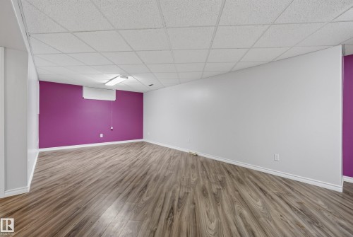 Spacious room featuring wood-finish flooring, white baseboards, and a dropped ceiling with integrated lighting - 3 Bristow Crescent, Spruce Grove, AB - Indoor Photo Showing Other Room