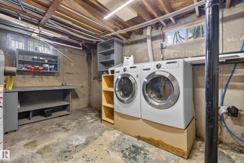 Utility area featuring concrete walls, exposed wood ceiling joists, and a built-in workbench with shelving - 3 Bristow Crescent, Spruce Grove, AB - Indoor Photo Showing Laundry Room