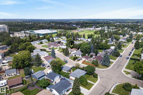 Residential neighborhood with tree-lined streets, a nearby athletic field, and a prominent building with a green roof - 3 Bristow Crescent, Spruce Grove, AB - Outdoor With View